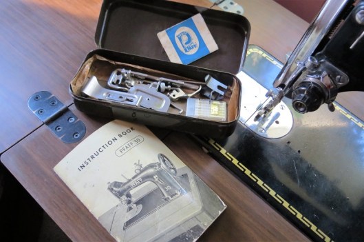 The original sewing machine manual and accessories tin.